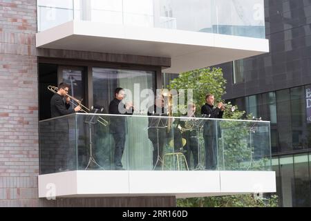 200905 -- LONDRES, le 5 septembre 2020 -- des membres du Royal Philharmonic Orchestra RPO se produisent sur un balcon du Breton Building à Wembley Park à Londres, en Grande-Bretagne, le 5 septembre 2020. Samedi, les musiciens du RPO ont surpris les membres du public avec la première performance live du RPO depuis le début du confinement en mars, jouant en espace libre pour permettre la distanciation sociale. Photo de /Xinhua BRITAIN-LONDON-WEMBLEY PARK-ROYAL PHILHARMONIC ORCHESTRA-PERFORMANCE RayxTang PUBLICATIONxNOTxINxCHN Banque D'Images