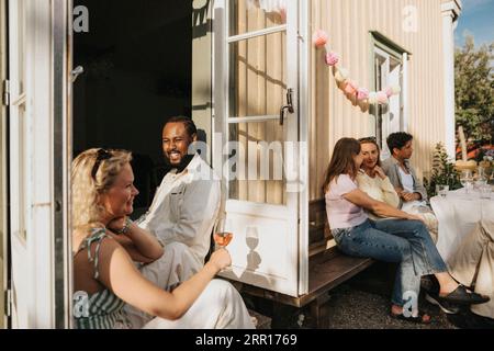 Amis s'amusant tout en célébrant les uns avec les autres pendant le dîner au café Banque D'Images