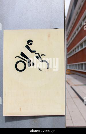 Pas de signalisation routière de conduite de moto sur un fond plat d'un côté et un couloir pour lui donner de la profondeur de l'autre Banque D'Images