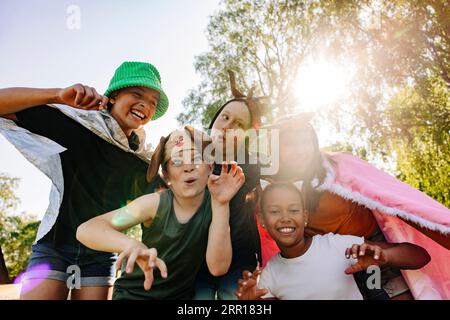 Portrait d'enfants heureux faisant des gestes et faisant des visages tout en jouant ensemble au camp d'été Banque D'Images