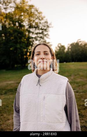 Portrait d'une femme souriante portant une veste tout en se tenant debout dans le terrain de jeu Banque D'Images