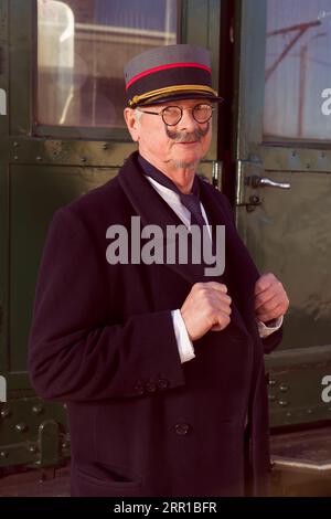 Scène de reconstitution d'un ancien conducteur de chemin de fer au départ du train de première classe Banque D'Images