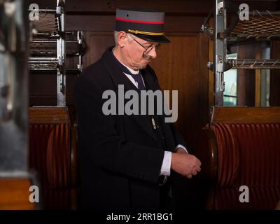 Scène de reconstitution d'un ancien chef de train à vapeur dans un intérieur de train authentique de première classe en 1927 Banque D'Images