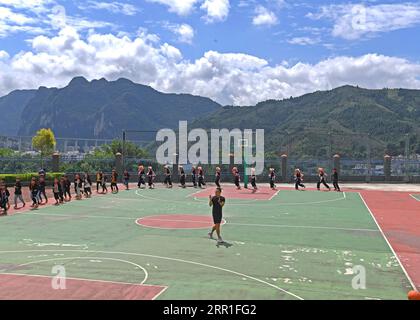 200915 -- LINGYUN, 15 septembre 2020 -- le front de Shen Yequan et ses élèves effectuent un échauffement lors d'un cours de basket-ball à l'école primaire Lanjin, dans le canton de Sicheng, dans le comté de Lingyun, dans la région autonome de Guangxi Zhuang, dans le sud de la Chine, le 8 septembre 2020. Shen, 28 ans, est le seul professeur d'éducation physique de l'école du village. Il a été affecté à enseigner l'éducation physique à l'école en 2018 après avoir obtenu un baccalauréat en sport. En raison de nos efforts inlassables, les enfants ont un fort désir d'activités physiques. Je vais rester à mon poste ici pour aider les enfants ruraux à cultiver l'habitude de faire du sport Banque D'Images