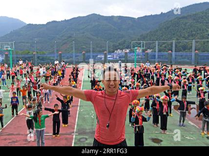 200915 -- LINGYUN, 15 septembre 2020 -- le Front Shen Yequan et ses élèves pratiquent la calisthénique diffusée pendant une pause scolaire à l'école primaire Lanjin dans le canton de Sicheng, dans le comté de Lingyun, dans la région autonome de Guangxi Zhuang, dans le sud de la Chine, le 10 septembre 2020. Shen, 28 ans, est le seul professeur d'éducation physique de l'école du village. Il a été affecté à enseigner l'éducation physique à l'école en 2018 après avoir obtenu un baccalauréat en sport. En raison de nos efforts inlassables, les enfants ont un fort désir d'activités physiques. Je vais rester à mon poste ici pour aider les enfants ruraux à cultiver l'habitude de participer Banque D'Images