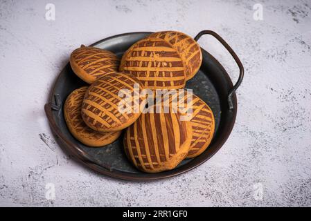 Plusieurs biscuits en pain d'épice à la cannelle, dans une assiette en métal, sur fond blanc Banque D'Images