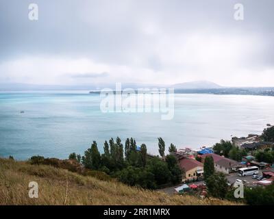 Sevan, Arménie - 25 août 2023 : vue au-dessus du lac Sevan et aire de stationnement depuis le monastère de Sevanavank lors d'une journée nuageuse d'été, Arménie Banque D'Images