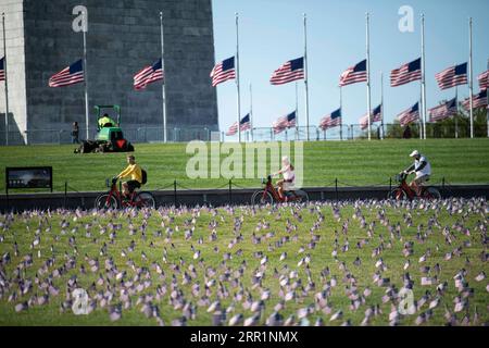 200922 -- WASHINGTON, le 22 septembre 2020 -- les gens montent à vélo devant les drapeaux nationaux américains représentant les 200 000 vies perdues à cause du COVID-19 aux États-Unis placés au National Mall à Washington, D.C., aux États-Unis, le 22 septembre 2020. Le nombre de décès dus à la COVID-19 aux États-Unis a dépassé 200 000 mardi, selon le Center for Systems Science and Engineering CSSE de l’Université Johns Hopkins. U.S.-WASHINGTON, D.C.-COVID-19-DEATHS-200,000-COVID MEMORIAL PROJECT LIUXJIE PUBLICATIONXNOTXINXCHN Banque D'Images