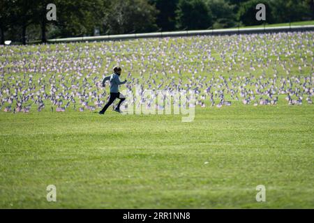 200922 -- WASHINGTON, le 22 septembre 2020 -- Un garçon court devant les drapeaux nationaux américains représentant les 200 000 vies perdues à cause du COVID-19 aux États-Unis placés au National Mall à Washington, D.C., aux États-Unis, le 22 septembre 2020. Le nombre de décès dus à la COVID-19 aux États-Unis a dépassé 200 000 mardi, selon le Center for Systems Science and Engineering CSSE de l’Université Johns Hopkins. U.S.-WASHINGTON, D.C.-COVID-19-DEATHS-200,000-COVID MEMORIAL PROJECT LIUXJIE PUBLICATIONXNOTXINXCHN Banque D'Images