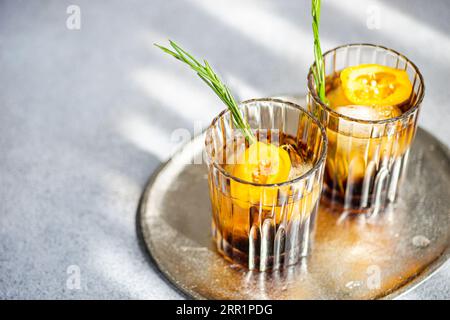 Angle élevé de cocktails Margarita épicés servis avec des glaçons et des tranches de fruits frais placés sur un plateau sur fond gris Banque D'Images
