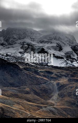 Vue aérienne de la chaîne de montagnes et des sommets couverts par la neige situés sous le ciel nuageux à Zermatt, Suisse Banque D'Images