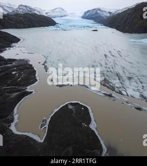 Vue aérienne de l'eau brune gelée du lac avec des fissures de glace entre les montagnes enneigées de l'île de Madère Portugal sous ciel bleu flou sans nuages dans da Banque D'Images