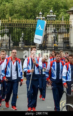 Groupe de nageurs des Olympiens de l'équipe GB quittant Buckingham Palace après le défilé de la victoire. Jeux olympiques de Londres 2012. Panneau de natation Banque D'Images