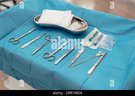 D'en haut assortiment d'outils chirurgicaux propres de forceps et de pincettes avec des ciseaux et un scalpel avec des seringues et un plateau dans la clinique médicale Banque D'Images