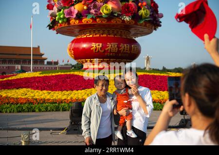 200924 -- PÉKIN, 24 septembre 2020 -- des touristes posent pour des photos devant un panier de fleurs sur la place Tian anmen à Pékin, capitale de la Chine, le 24 septembre 2020. L'affichage de 18 mètres de haut en forme de panier de fleurs est placé au centre de la place Tian anmen comme décoration pour les prochaines vacances de la fête nationale. CHINE-BEIJING-TIAN ANMEN PANIER DE FLEURS CARRÉES CN CHENXZHONGHAO PUBLICATIONXNOTXINXCHN Banque D'Images