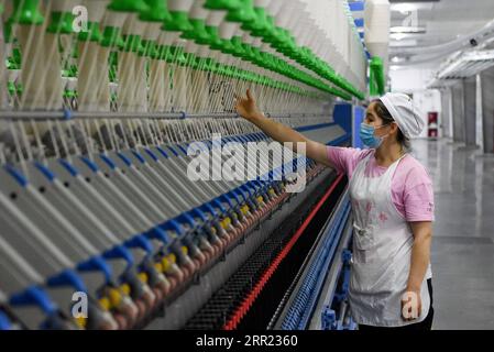 200930 -- URUMQI, 30 septembre 2020 -- un employé travaille dans une usine textile dans le comté de Yuli de la préfecture autonome mongole de Bayan Gol, région autonome ouïgour du Xinjiang, au nord-ouest de la Chine, 24 août 2020. La région autonome ouïgoure du Xinjiang du Nord-Ouest de la Chine a créé quelque 2 millions de nouveaux emplois pour ses résidents de 2014 à 19. Depuis le 18e Congrès national du PCC du Parti communiste chinois en 2012, le Xinjiang a mis en œuvre énergiquement des projets d ' emploi et amélioré la formation professionnelle, et a élargi les filières et les capacités d ' emploi. De 2014 à 19, le nombre total de personnes employées i Banque D'Images