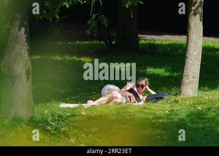 Une femme se détend à l'ombre d'un arbre alors qu'elle profite du temps qu'elle fait à Sefton Park à Liverpool. Les prévisionnistes prédisent une «dernière dose de l'été», avec des périodes chaudes atteignant 32C mercredi et jeudi dans le centre et le sud de l'Angleterre. Date de la photo : mercredi 6 septembre 2023. Banque D'Images