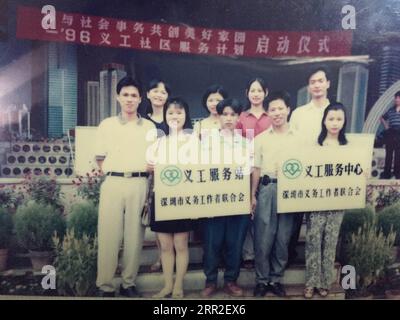 201010 -- SHENZHEN, 10 octobre 2020 -- Xiong Yonglan 2e L, devant pose pour une photo alors qu'elle tient la plaque du premier centre de service bénévole communautaire du district de Bao an à Shenzhen, dans la province du Guangdong du sud de la Chine, le 24 août 1996. Xiong Yonglan, qui est maintenant gestionnaire au palais des jeunes du district de Bao an à Shenzhen, s'efforce d'améliorer la vie dans la ville depuis le moment où elle est entrée dans la ville. En 1992, Xiong Yonglan, âgé de 18 ans, est arrivé à la succursale de Shenzhen de Mabuchi Motor et a travaillé sur la chaîne de montage. Bientôt, avec ses performances exceptionnelles sur le terrain, Xiong est devenue une Banque D'Images