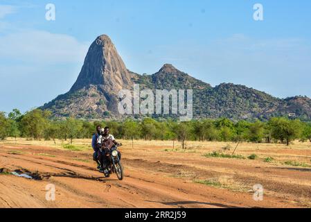 201013 -- BEIJING, 13 octobre 2020 -- les habitants de la région conduisent une moto devant le pic Mindif à Maroua, Cameroun, le 9 juin 2018. Photo de /Xinhua AFRIQUE-PAYSAGE NATUREL-CULTUREL PERSONNALISÉ JeanxPierrexKepseu PUBLICATIONxNOTxINxCHN Banque D'Images