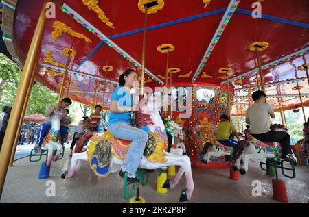 201015 -- HEFEI, 15 octobre 2020 -- une photo de dossier prise le 31 mai 2010 montre Wang Xiangjun devant un carrousel dans un parc d'attractions à Hefei, dans la province de l'Anhui de l'est de la Chine. POUR ALLER AVEC à travers la Chine : piano jette la lumière, mélodie sur un monde de ténèbres CHINE-ANHUI-ÉDUCATION SPÉCIALE-PROFESSEUR DE PIANO CN LiuxJunxi PUBLICATIONxNOTxINxCHN Banque D'Images
