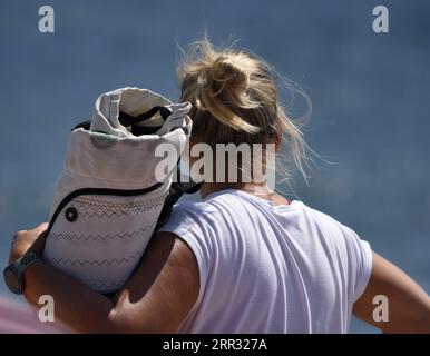 Jeune femme blonde kitesurfer avec équipement sur le rivage d'Artemida en Attique, Grèce. Banque D'Images