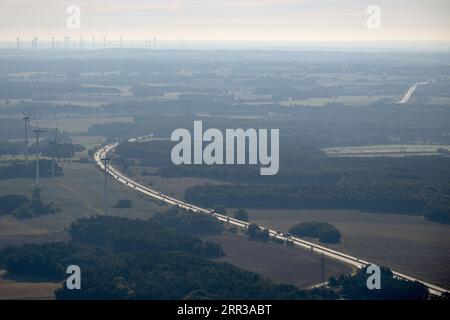 Putlitz, Allemagne. 05 septembre 2023. Les voitures roulent sur l'autoroute 24. A côté d'eux se trouvent des éoliennes. Crédit : Sebastian Gollnow/dpa/Alamy Live News Banque D'Images