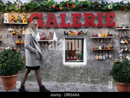 201029 -- PARIS, le 29 octobre 2020 -- Une femme passe devant une boutique de porcelaine à Montmartre, Paris, France, le 28 octobre 2020. La France entrera en confinement national à partir de vendredi pour endiguer la deuxième vague de l’épidémie de coronavirus, a annoncé mercredi soir le président Emmanuel Macron. La France a enregistré mercredi 36 437 nouvelles infections à COVID-19, 3 020 de plus que le nombre enregistré au cours des 24 heures précédentes. Le nombre cumulé de cas de coronavirus a grimpé à 1 235 132, dont 35 785 décès, en hausse de 244 en une journée, ont montré les chiffres publiés par l’Agence de la santé publique. FRANCE-PARIS-LOCKDOWN Banque D'Images