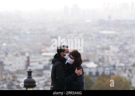 201029 -- PARIS, le 29 octobre 2020 -- Un couple s'étreint et s'embrassait au Montmartre, Paris, France, le 28 octobre 2020. La France entrera en confinement national à partir de vendredi pour endiguer la deuxième vague de l’épidémie de coronavirus, a annoncé mercredi soir le président Emmanuel Macron. La France a enregistré mercredi 36 437 nouvelles infections à COVID-19, 3 020 de plus que le nombre enregistré au cours des 24 heures précédentes. Le nombre cumulé de cas de coronavirus a grimpé à 1 235 132, dont 35 785 décès, en hausse de 244 en une journée, ont montré les chiffres publiés par l’Agence de la santé publique. FRANCE-PARIS-CONFINEMENT GAOXJING PUBLICAT Banque D'Images