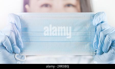 Détail d'un visage de femme méconnaissable portant un masque médical et des gants. Coronavirus, quarantaine COVID-19. Concept médecin, infirmière. Banque D'Images