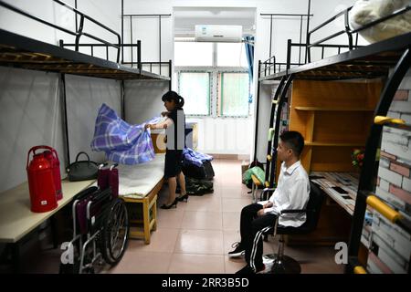 201029 -- HEFEI, le 29 octobre 2020 -- Cheng Dongdong et sa mère arrivent au dortoir de l'Université Chaohu à Chaohu, province de l'Anhui dans l'est de la Chine, le 17 septembre 2020. Né dans la ville de Qiucun de Guangde City en 2001, Cheng Dongdong a été diagnostiqué avec la sclérose latérale amyotrophique SLA en 2008. De l'école primaire au lycée, Cheng avait reçu de l'aide de ses camarades de classe. En septembre 2020, Cheng a commencé sa vie universitaire et a obtenu le soutien de ses nouveaux camarades de classe comme avant. CHINE-ANHUI-UNIVERSITÉ ÉTUDIANT-ALS-SOUTIEN DE CAMARADES DE CLASSE CN ZHANGXDUAN PUBLICATIONXNOTXINXCHN Banque D'Images