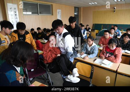 201029 -- HEFEI, 29 octobre 2020 -- des camarades de classe portent Cheng Dongdong dans une salle de classe à l'Université Chaohu à Chaohu, province de l'Anhui dans l'est de la Chine, le 19 octobre 2020. Né dans la ville de Qiucun de Guangde City en 2001, Cheng Dongdong a été diagnostiqué avec la sclérose latérale amyotrophique SLA en 2008. De l'école primaire au lycée, Cheng avait reçu de l'aide de ses camarades de classe. En septembre 2020, Cheng a commencé sa vie universitaire et a obtenu le soutien de ses nouveaux camarades de classe comme avant. CHINE-ANHUI-UNIVERSITÉ ÉTUDIANT-ALS-SOUTIEN DE CAMARADES DE CLASSE CN LIUXJUNXI PUBLICATIONXNOTXINXCHN Banque D'Images