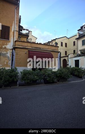 Devant un restaurant fermé dans une rue d'une ville italienne au coucher du soleil Banque D'Images