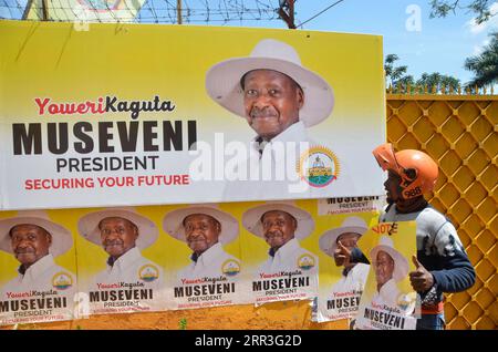 201102 -- KAMPALA, le 2 novembre 2020 -- Un partisan du président sortant Yoweri Museveni est photographié à côté d'un mur d'affiches à Kampala, Ouganda, le 2 novembre 2020. Le corps électoral ougandais a commencé lundi à désigner des candidats à la présidence pour les élections générales de 2021. Le juge Simon Mugenyi Byabakama, président de la Commission électorale, a déclaré que dix candidats potentiels ont été vérifiés et approuvés pour les nominations lors de l'exercice de nomination de deux jours qui s'est tenu sur le terrain de cricket de l'Université Kyambogo, à environ neuf kilomètres à l'est de la capitale Kampala. Photo de /Xinhua OUGANDA-KAMPALA-CANDIDATS À LA PRÉSIDENCE Banque D'Images