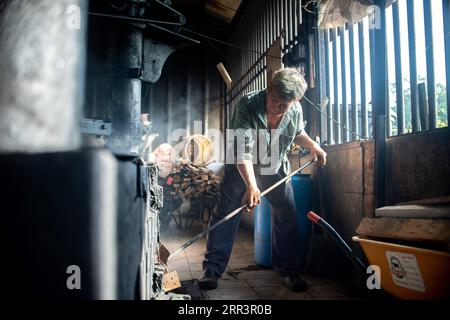 201109 -- KLANG, 9 novembre 2020 -- Tan Loon Chuan utilise des combustibles avec du bois pendant le processus de friture des grains de café à l'usine de café Chuan Hoe à Klang, dans l'État de Selangor, Malaisie, 6 novembre 2020. Kopi O , la version malaisienne du café noir, est l'un des favoris des habitants de tous les temps. Chuan Hoe Coffee Factory est une usine de café traditionnelle située à Klang, qui produit de la poudre de Kopi O depuis plus de six décennies. C'est l'une des rares usines en Malaisie qui insistent encore sur la production de leur poudre de café en utilisant la méthode de torréfaction au charbon de bois. Tan Loon Chuan, 63 ans, est la troisième génération héritière du Banque D'Images