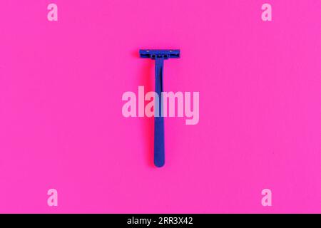 Machine de rasage en plastique bleu non permanent isolé sur fond rose Banque D'Images