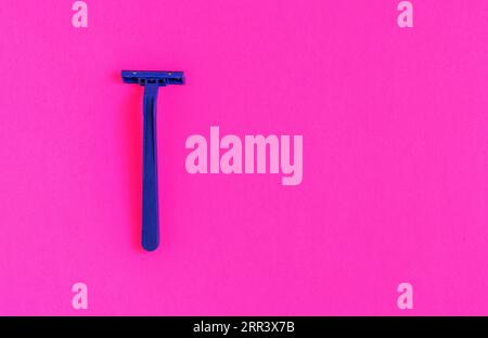 Machine de rasage en plastique bleu non permanent isolé sur fond rose Banque D'Images