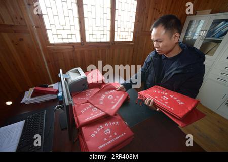 201115 -- YUPING, le 15 novembre 2020 -- Un fonctionnaire du village trie les dossiers familiaux pauvres au village de Tiejiaxi, dans le comté autonome de Yuping Dong, dans la province du Guizhou, au sud-ouest de la Chine, le 14 novembre 2020. Le village de Tiejiaxi était l'un des 14 villages en proie à la pauvreté dans le comté. Depuis 2014, le gouvernement local a fait de grands efforts pour aider les villageois à se débarrasser de la pauvreté. D ' une part, le gouvernement local a amélioré l ' infrastructure et a essayé d ' amener les villageois à s ' engager dans une industrie éco-agricole, et d ' autre part, il a apporté son soutien à des ateliers locaux de lutte contre la pauvreté afin de renforcer l ' emploi Banque D'Images