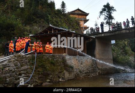 201120 -- RONGSHUI, 20 novembre 2020 -- des femmes volontaires participent à un exercice de lutte contre les incendies sous la direction de pompiers professionnels au village de Wuying, un village isolé habité par le groupe ethnique Miao à la frontière entre la région autonome du Guangxi Zhuang du sud de la Chine et la province du Guizhou du sud-ouest de la Chine, le 19 novembre 2020. Comme les maisons avec le style architectural local dans le village sont soutenues par une structure boisée, une équipe de pompiers volontaires femmes sont formées pour protéger leur village alors que la plupart des hommes jeunes et d'âge moyen s'aventurent comme migrants. CHINE-GUANGXI-RONGSHUI-VILLAGE DE MIAO-V. Banque D'Images