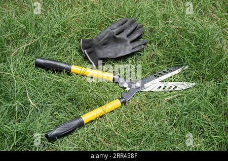 Tondeuse à gazon jaune couchée sur l'herbe Banque D'Images