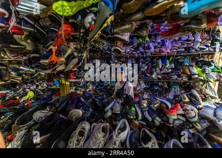 Dezerter Bazaar est le plus grand marché alimentaire de Tbilissi. Le marché vend également des vêtements vintage et une grande sélection de chaussures de marque dans un entrepôt de tôle ondulée. Des plans circulent depuis début 2024 pour que le bâtiment principal fasse place à un centre commercial et que des centaines de commerçants perdent leurs stands autour de l’ancien bâtiment. Marché de chaussures de Tbilissi, Géorgie Banque D'Images