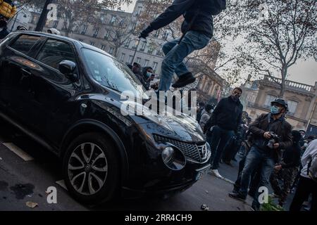 201129 -- PARIS, le 29 novembre 2020 -- Un manifestant monte sur une voiture lors d'affrontements avec la police lors d'une manifestation à Paris, France, le 28 novembre 2020. Des violences ont éclaté entre la police et les manifestants à Paris et dans d'autres villes françaises lors des manifestations de samedi contre un projet de loi controversé qui restreint la publication d'images de police. Photo de /Xinhua FRANCE-PARIS-DÉMONSTRATION AurelienxMorissard PUBLICATIONxNOTxINxCHN Banque D'Images