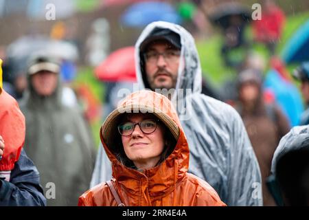 Un couple dans Wets dans l'arène principale Mountain Stage dans la pluie et la boue de pluie. Green Man Festival, Brecon, pays de Galles, Royaume-Uni, 2023. Photo : Rob Watkins Banque D'Images