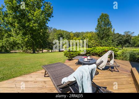 Un couple de chaises longues modernes sur une terrasse dans une maison de campagne. Banque D'Images