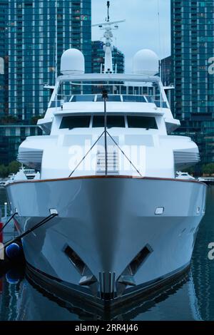 Vue sur le bateau de luxe amarré aux Melbourne docklands en soirée avec en toile de fond la ville, Yarra River, Melbourne, Australie. Banque D'Images