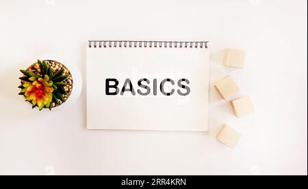 Le mot BASICS écrit sur un bloc-notes et un fond blanc Banque D'Images