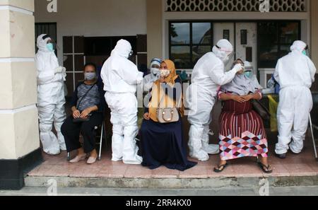 201208 -- SURABAYA, 8 décembre 2020 -- des travailleurs médicaux portant des combinaisons de protection prélèvent des échantillons de femmes enceintes pour le test COVID-19 à Surabaya, Indonésie, le 8 décembre 2020. Photo de /Xinhua INDONESIA-SURABAYA-TEST-COVID-19 Kurniawan PUBLICATIONxNOTxINxCHN Banque D'Images