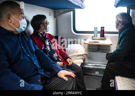 201209 -- URUMQI, le 9 décembre 2020 -- les passagers regardent le paysage devant la fenêtre du train K9756 de Korla à Yetimbulak, dans la région autonome ouïgoure du Xinjiang du nord-ouest de la Chine, le 9 décembre 2020. Le train circule sur la section Xinjiang de la ligne Golmud-Korla. Le chemin de fer Golmud-Korla de 1 206 km reliant la ville de Golmud dans la province du Qinghai et la ville de Korla dans la région autonome ouïgoure du Xinjiang, toutes deux situées dans le nord-ouest de la Chine, a été mis en service mercredi. La nouvelle artère ferroviaire, qui réduira le temps de trajet entre Golmud et Korla d'environ 26 heures à environ 12 heures, est la troisième ligne de chemin de fer facilitant ex Banque D'Images