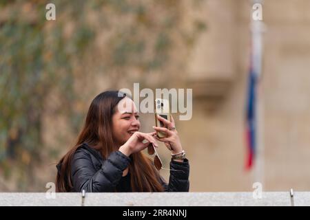 Jeune femme asiatique prenant la photographie et la vidéo avec un téléphone portable moment candide dans la ville de Melbourne, Australie. Banque D'Images