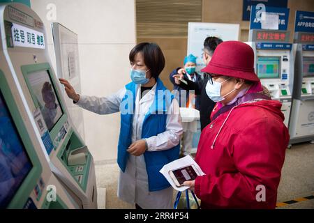 201210 -- BEIJING, le 10 décembre 2020 -- Un membre du personnel aide une personne âgée à vérifier les informations de rendez-vous sur une machine à l'hôpital Tiantan de Beijing de l'Université médicale de la capitale à Beijing, capitale de la Chine, le 9 décembre 2020. La Chine a lancé une campagne de trois ans pour aider les seniors du pays à franchir la fracture numérique et à profiter du développement de la technologie intelligente. Le gouvernement a récemment publié un plan spécifiant des mesures pour aider les personnes âgées à surmonter les obstacles à l'utilisation des technologies intelligentes tout en maintenant les services traditionnels pour elles. Le plan, émis par le Bureau général o Banque D'Images