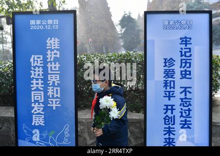 201213 -- NANJING, 13 décembre 2020 -- un élève tient un bouquet de fleurs lors d'une activité en commémoration des victimes du massacre de Nanjing dans un lieu de sépulture à l'occasion du septième jour commémoratif national à Nanjing, capitale de la province de Jiangsu de l'est de la Chine, le 13 décembre 2020. CHINE-NANJING MASSACRE-COMMÉMORATION CN Xinhua PUBLICATIONxNOTxINxCHN Banque D'Images